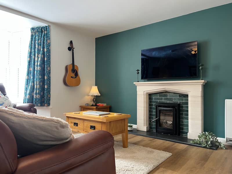 Sitting room of the Courtyard Apartment with fireplace and leather sofa
