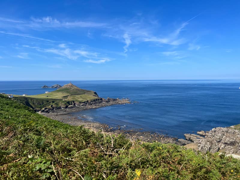 Cape Cornwall headland with its chimney, seen across the bay from the coast path